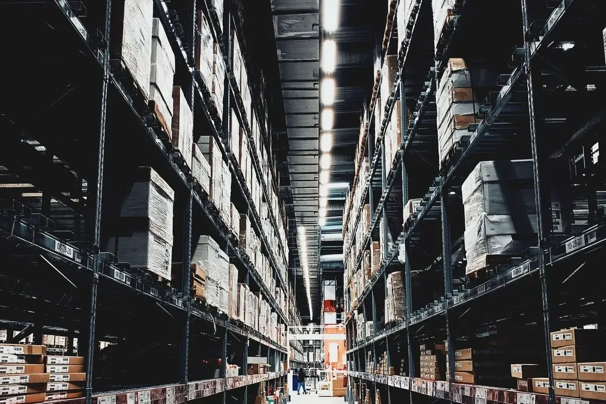 Warehouse aisle of boxed goods of the kind counted with handheld scanners when barcodes are in place.